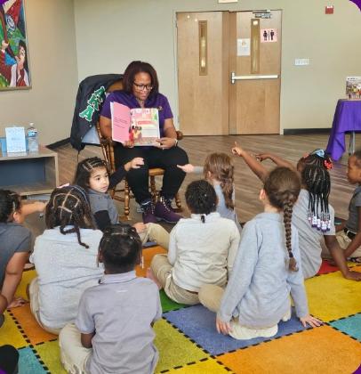 Akilah Darden sharing a book with children during storytime